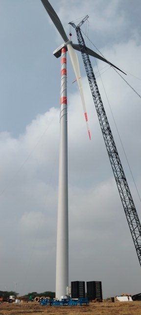 Wind turbine tower section being lifted into place