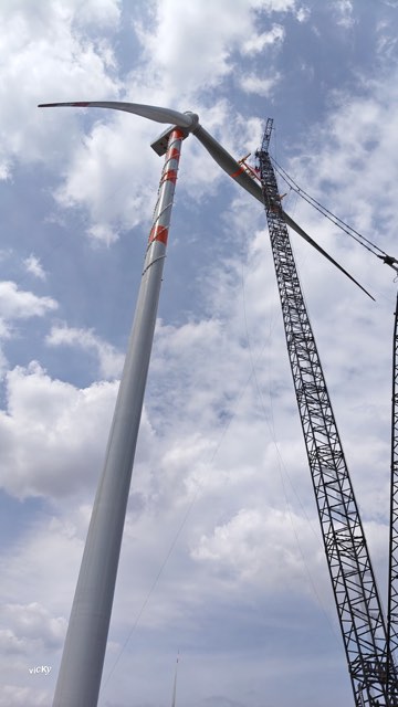 Crane assembling turbine tower sections
