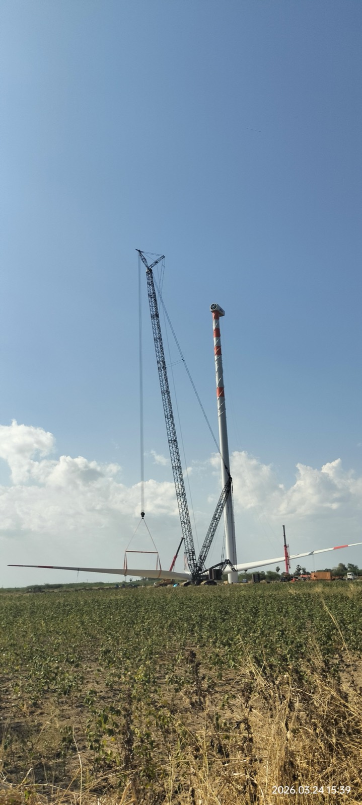 Crane assembling a wind turbine in the field
